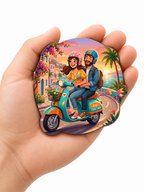 Fridge Magnet of a couple on a scooter with a tropical background held in a hand.